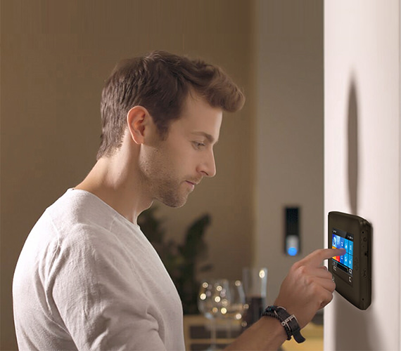 Man operates touch screen alarm panel